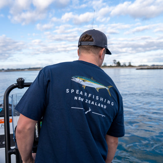 Person on a boat wearing a navy blue t-shirt with 'Spearfishing New Zealand' text and fish illustration.